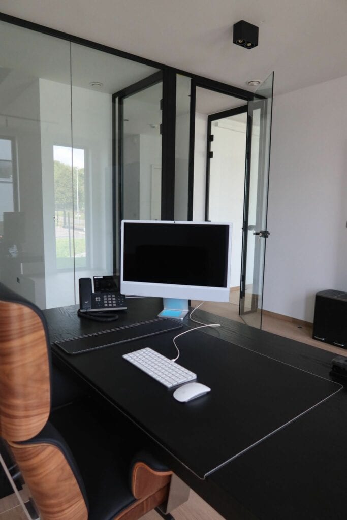 Bureau professionnel moderne avec cloison en verre dans un espace de coworking.