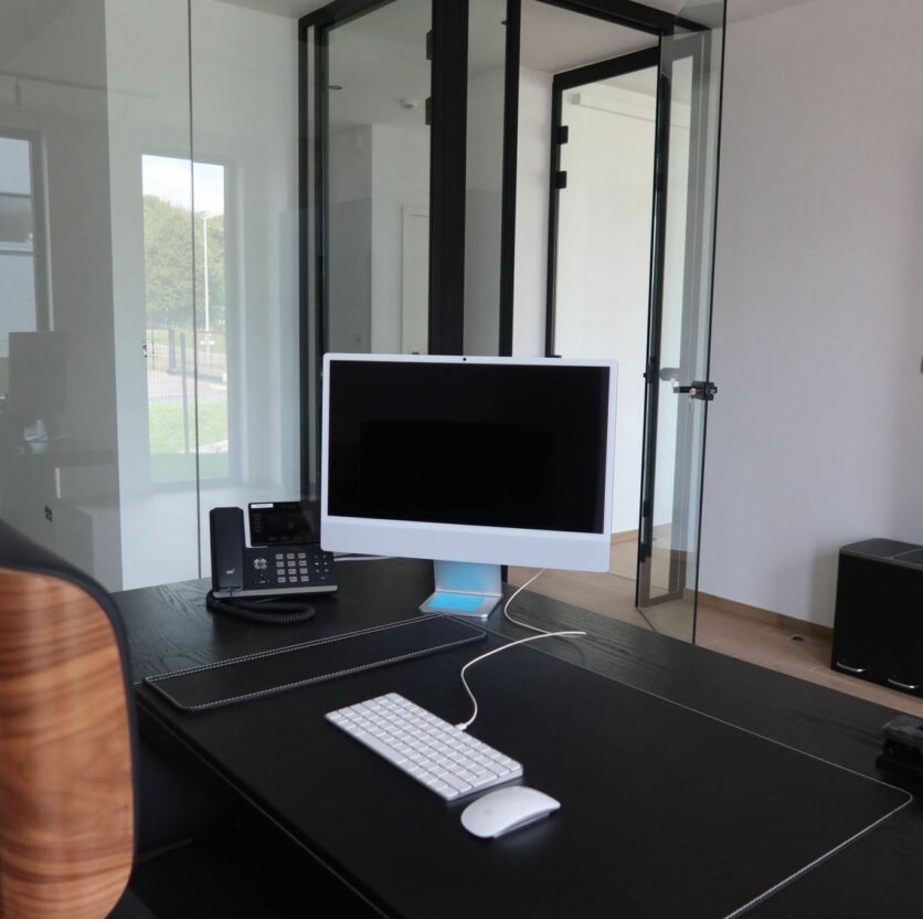 Bureau professionnel moderne avec cloison en verre dans un espace de coworking.